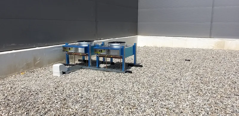 Technische buitenunit op een blauw frame op een plat grinddak